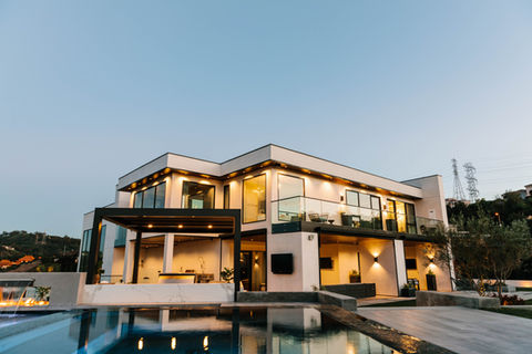 Luxury modern custom home with large glass windows, outdoor pool, and sleek architectural design built by Leli Construction in Southern California.