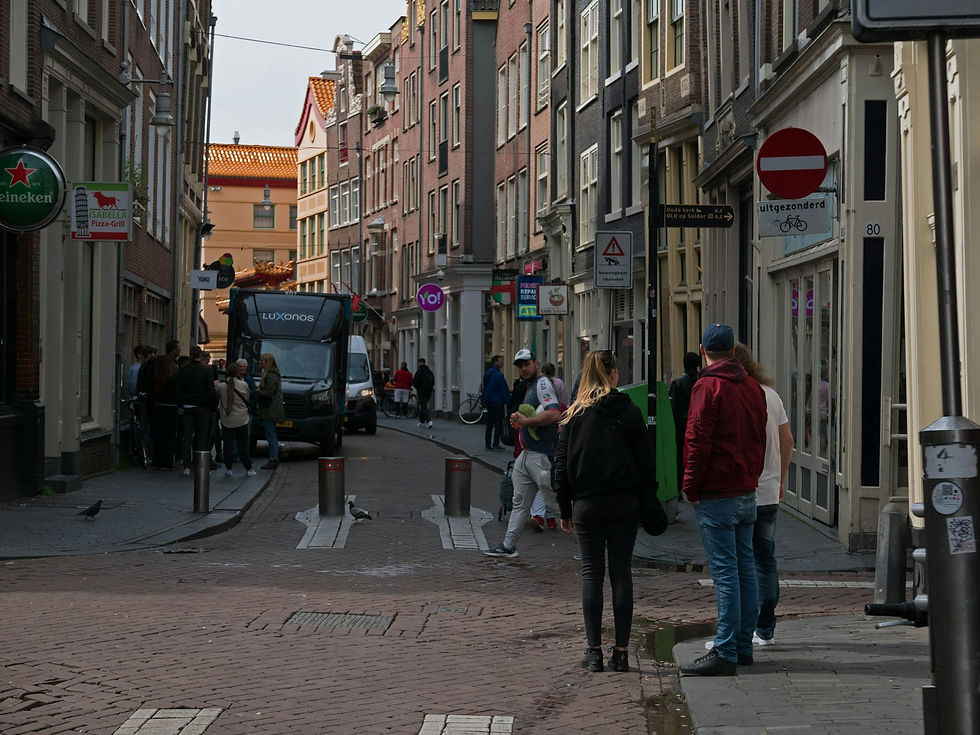 Groep mensen loopt door een straat tussen hoge gebouwen