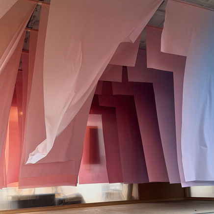 Banen doorschijnende stof in lagen die van roze naar lichtblauw verlopen, installatie Ways of Seeing op Dutch Design Week 2026