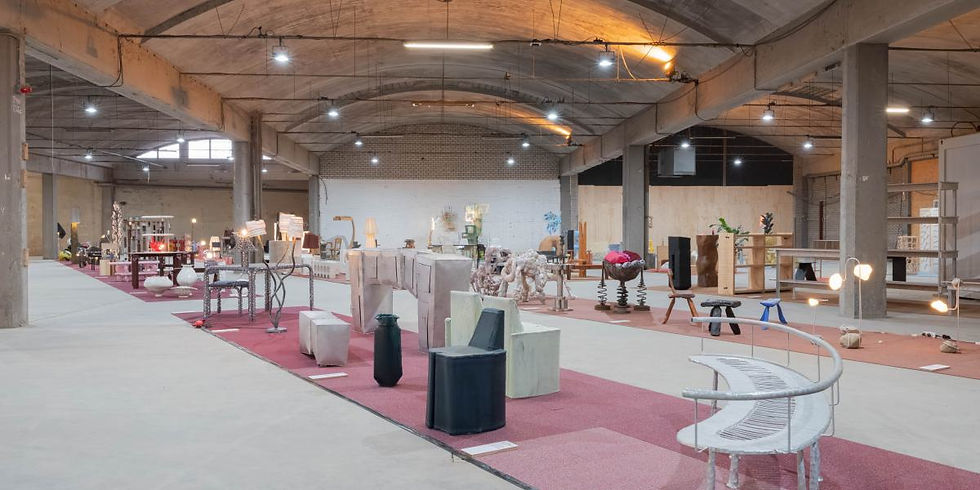 Lange fabriekshal met een roze looppad en meubelobjecten aan weerszijden
