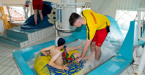 lifeguard helping kid into tube on the aquazone slide