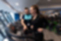 Personal trainer assisting client on treadmill at Campus Fitness