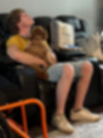 Young man and fluffy puppy napping in a recliner