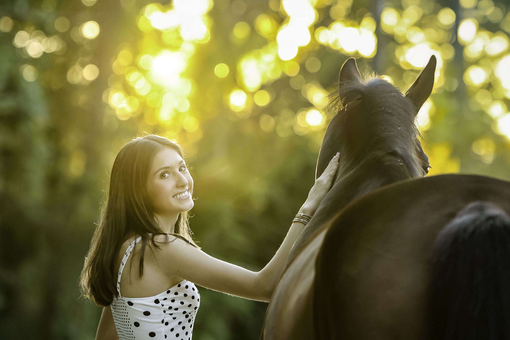 girl looks back at camera in a GA horse and rider photo session at sunset