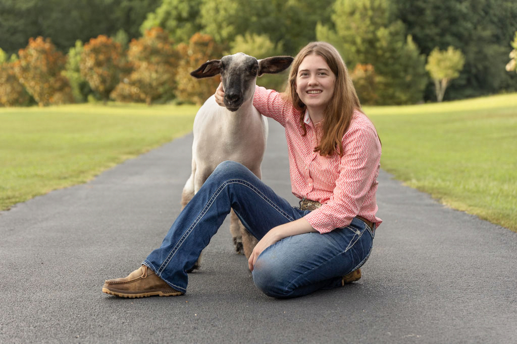 Georgia 4-H member poses with her sheep project in a livestock senior portrait