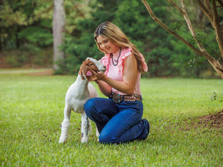 A GA FFA high school girl poses with her show goat 
