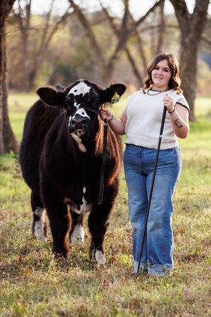 A FFA beef cattle exhibitor poses with her steer in her FFA livestock senior portraits