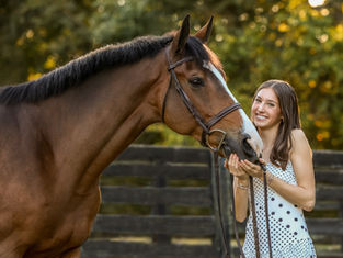 a girl poses with a bay horse in an equestrian photo session