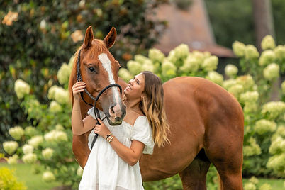 A Georgia high school senior looks at her chesnut horse in a horse and rider portrait