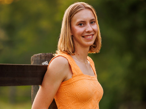 A high school senior girl poses with her paint horse in an equestrian senior portrait outside of Athens, GA