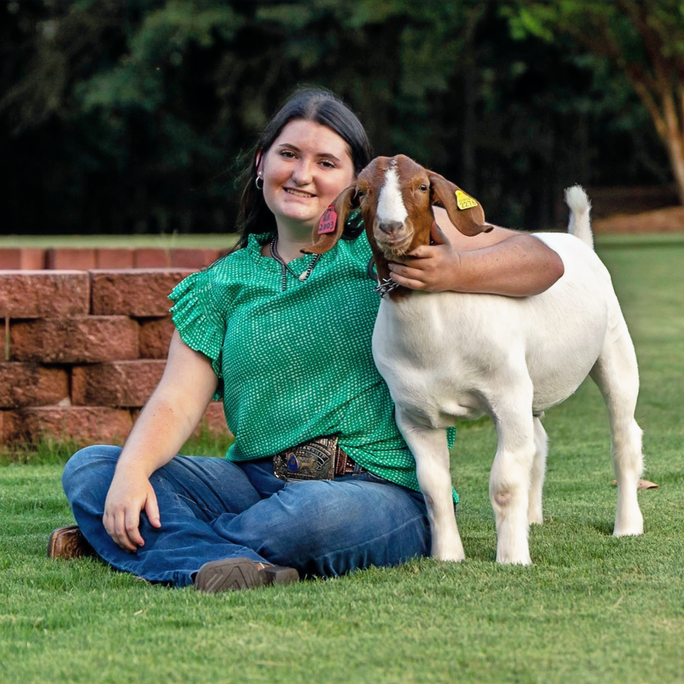 GA senior girl poses with goat in a livestock portrait
