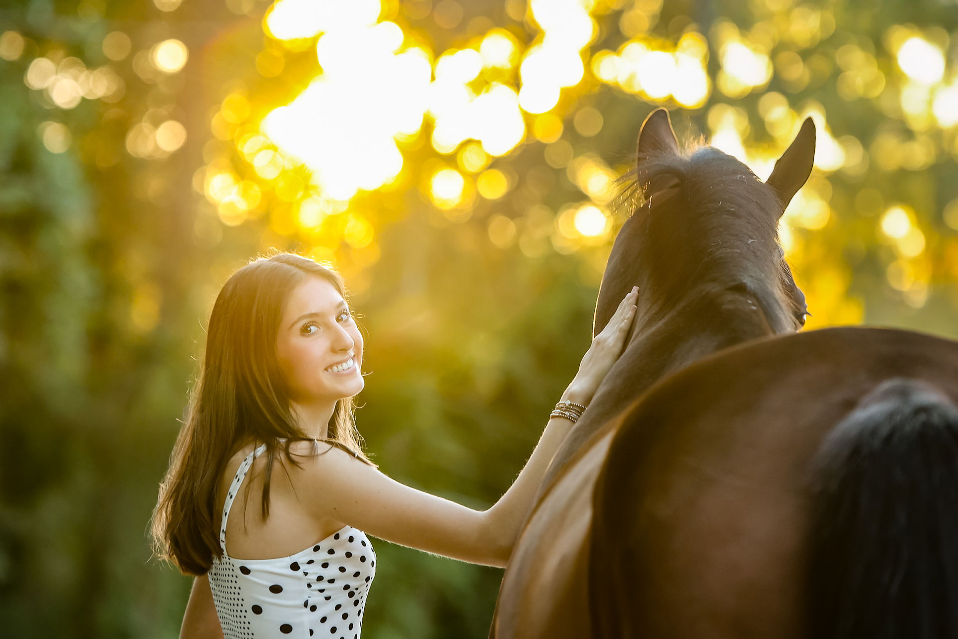 A Georgia girl poses with a bay horse in an equestrian portrait photo session