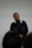 A Black Man Smiling With Their Hands Crossed.jpg