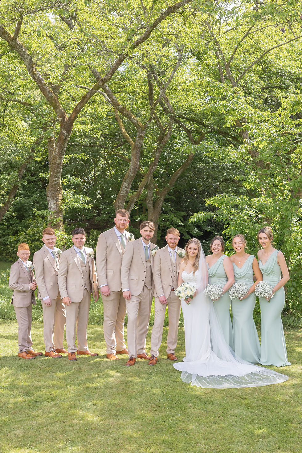 A bride and groom with their wedding party in the gardens of Norton Park Hotel.