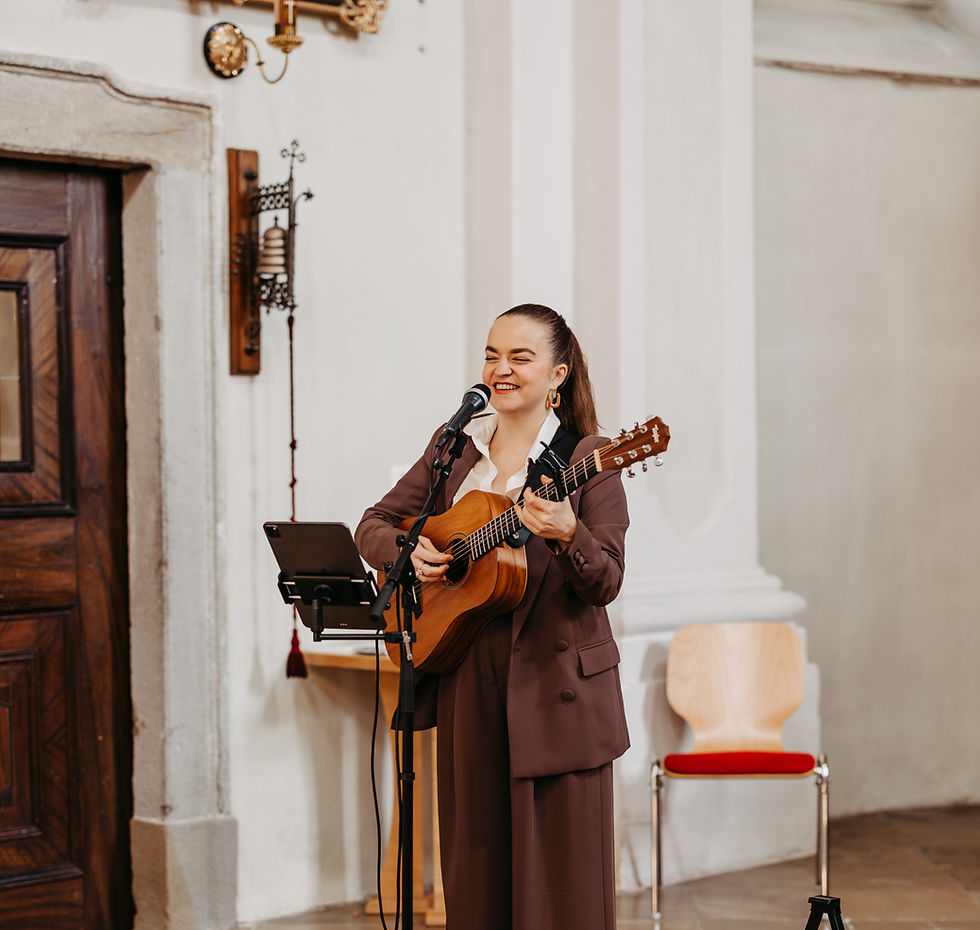 Taufsängerin Sara Wolfsberger von Sara Sings Live begleitet eine Taufe in Wien mit Gesang und Gitarre.