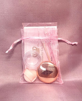 Touch-up Kit für klassisches Make-up – zartrosa Beutel mit Lippenstift-Döschen, Blotting Paper, Mini-Puder und Applikator.