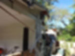 Storm-damaged home exterior before repairs, documenting damage for estimating and reconstruction planning.