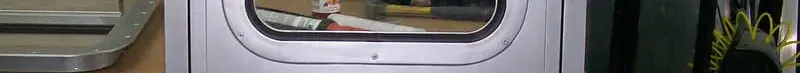 Aluminum marine watertight door with viewing window, dogging handles, and lever lockset, shop photo
