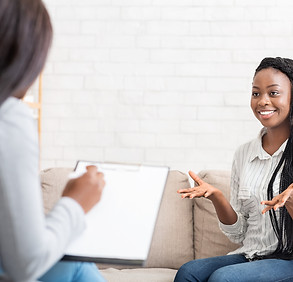 Happy_black_woman_talking_to_psychologist_after_successful_therapy_session.jpg
