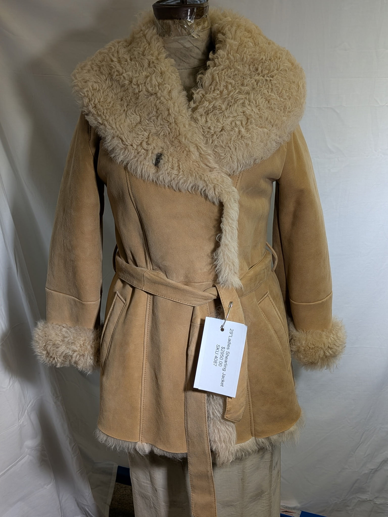 Tan shearling coat with a fur collar and matching belt.