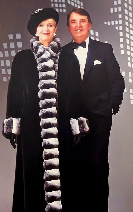 Brian and Joy Anderson standing together. Francis is wearing a long, beautiful black and white full length jacket