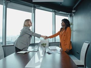 Older woman shaking younger woman's hand