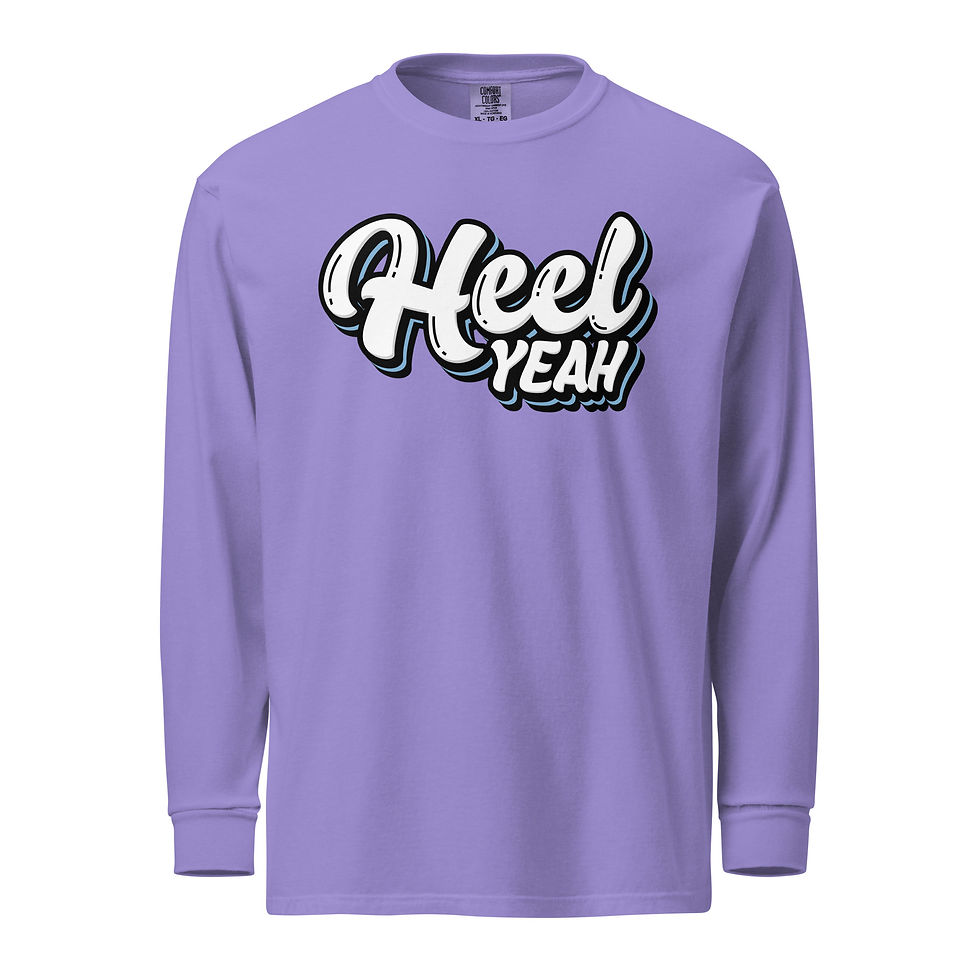 Thumbnail: Violet heavyweight long-sleeve shirt featuring the bold "Heel Yeah" design in white script with black and blue accents, displayed on a plain white background.