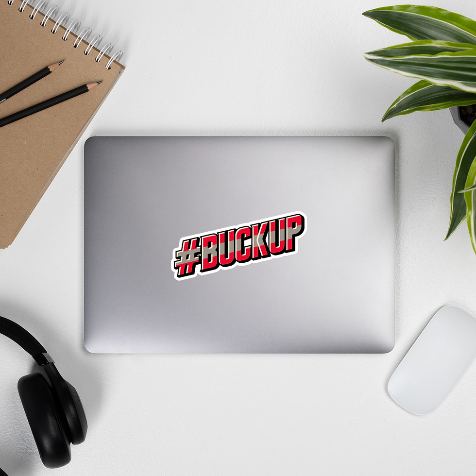 Silver laptop featuring a 5.5"x5.5" Columbus sports-inspired "#BuckUp" sticker with bold red and black text, surrounded by a notebook, headphones, and a plant on a white desk.