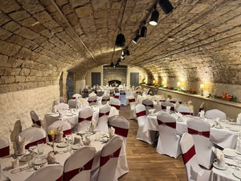Elegant banquet hall with stone walls, red sashes. Banquet Venue in Columbus Ohio.