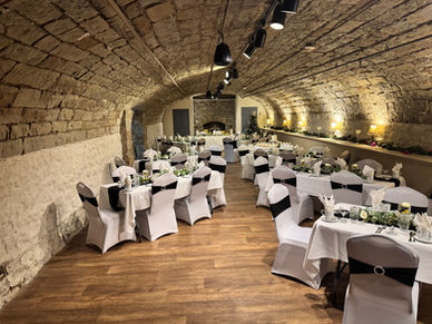 Arched stone wall banquet venue, white tables, black sashes, Columbus Ohio.