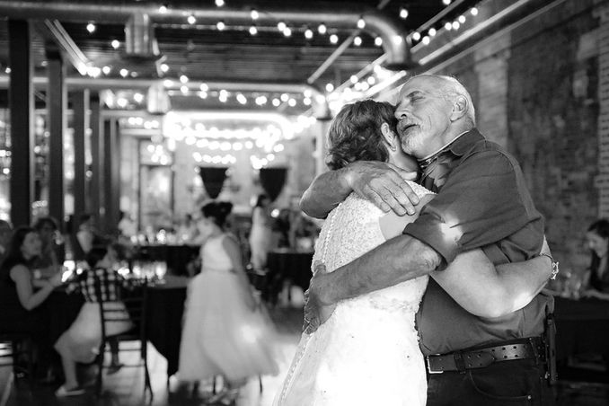Bride hugging her father on the dance floor at a wedding reception