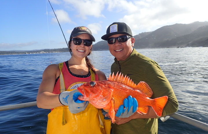 Moss Landing Marine Labs science crew member holding a Starry Rockfish (Sebastes constellatus) with volunteer angler prior to its release.