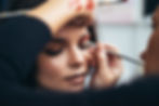 A woman having makeup applied to her face.