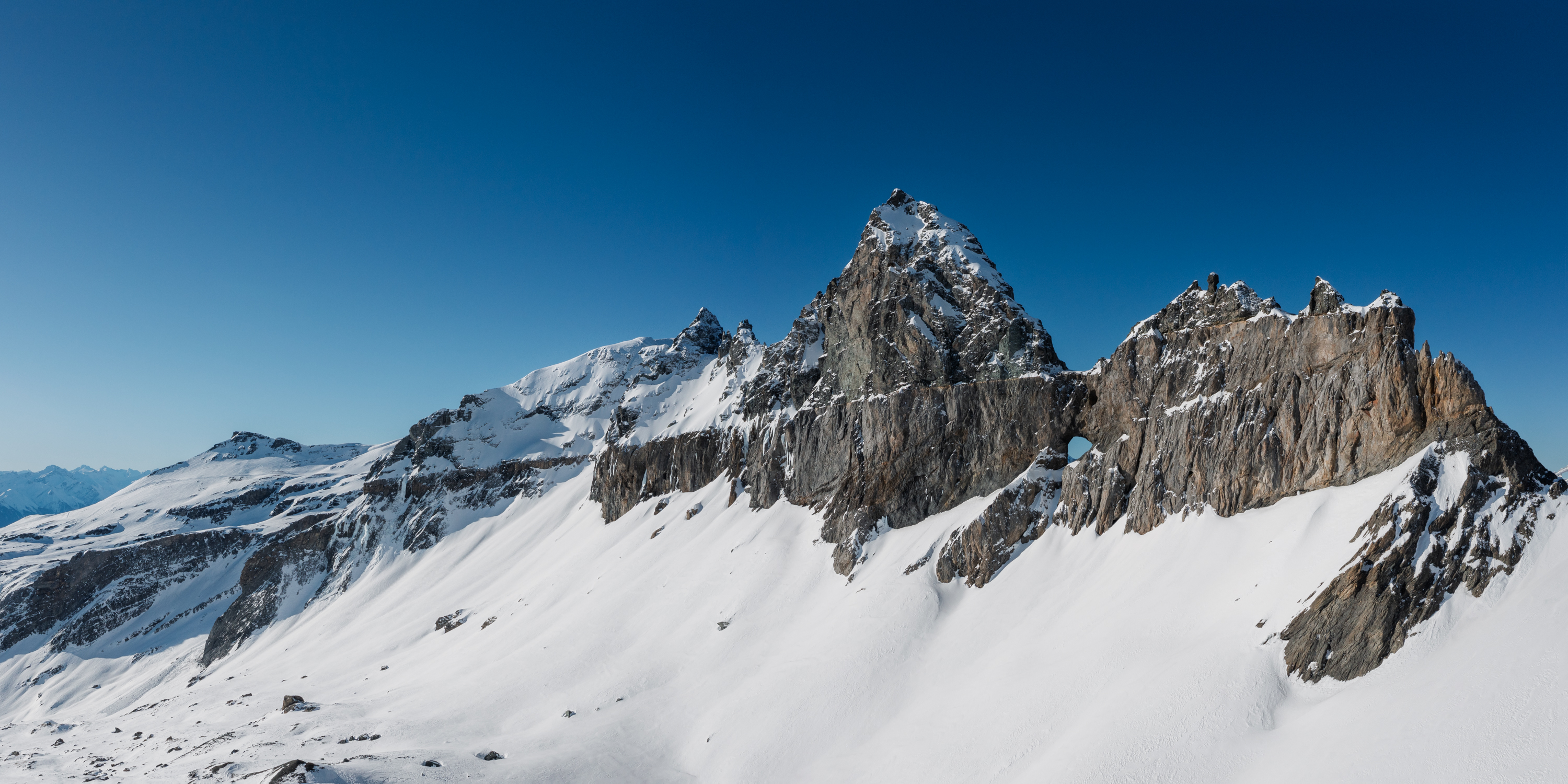 Martinsloch über verschneiter Felslandschaft unter klarem Winterhimmel