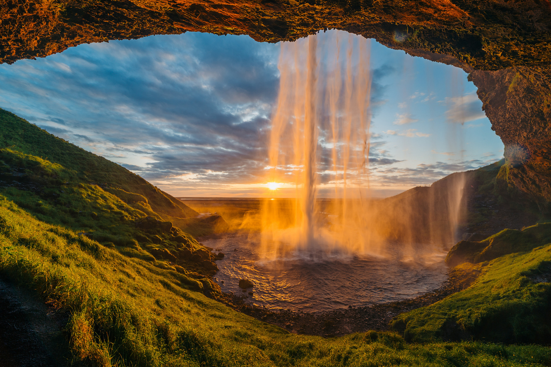 Seljalandsfoss aus einer Höhle im Gegenlicht der untergehenden Sonne