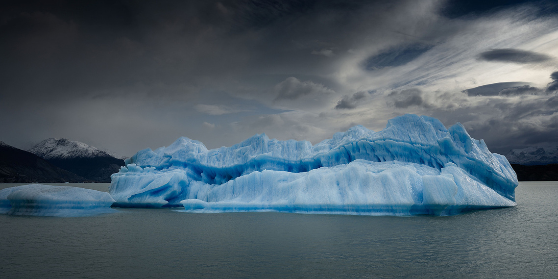 Blue Drift: blue iceberg on still water