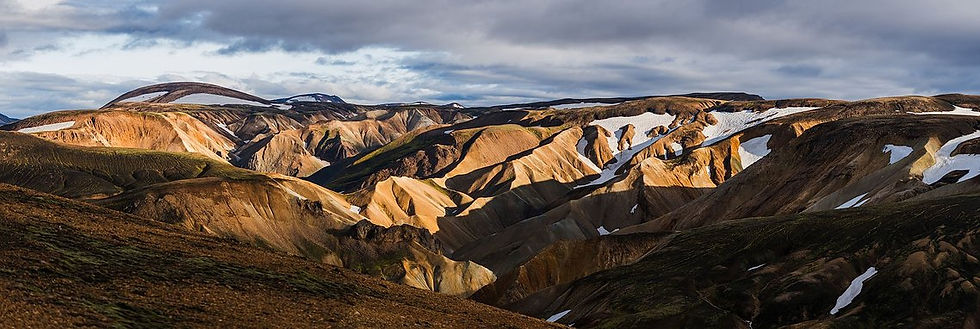 Ockerfarbene Rhyolithberge mit Schneefeldern in Landmannalaugar, Island