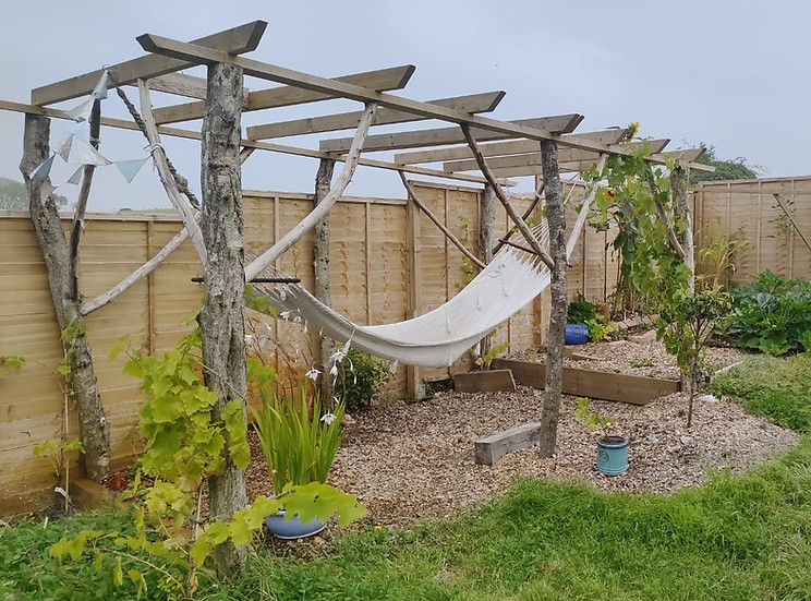 Garden with wooden pergola and white hammock