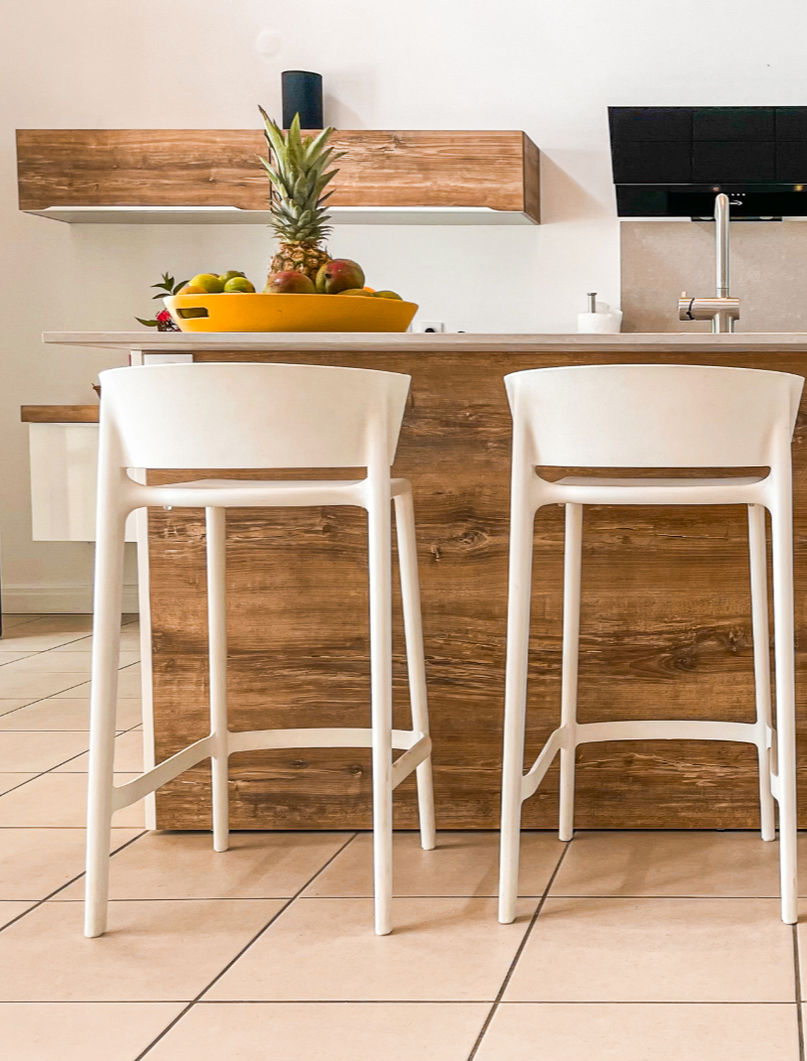 Plan de travail moderne et élégant de la cuisine de la villa Caraïbe Location, équipé de tout le nécessaire pour cuisiner : plaques de cuisson, évier, ustensiles et plan en granite, idéal pour un séjour confortable en Guadeloupe.
