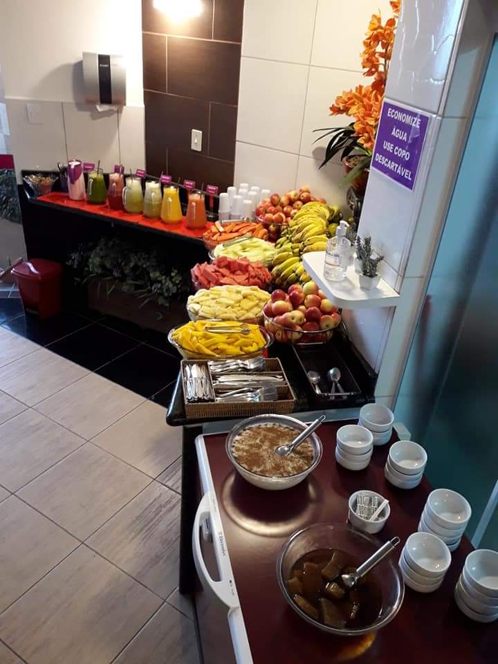 Mesa de frutas, sucos e granola do café da manhã