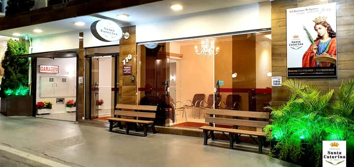 Entrada da pousada com bancos, recepção e garagem