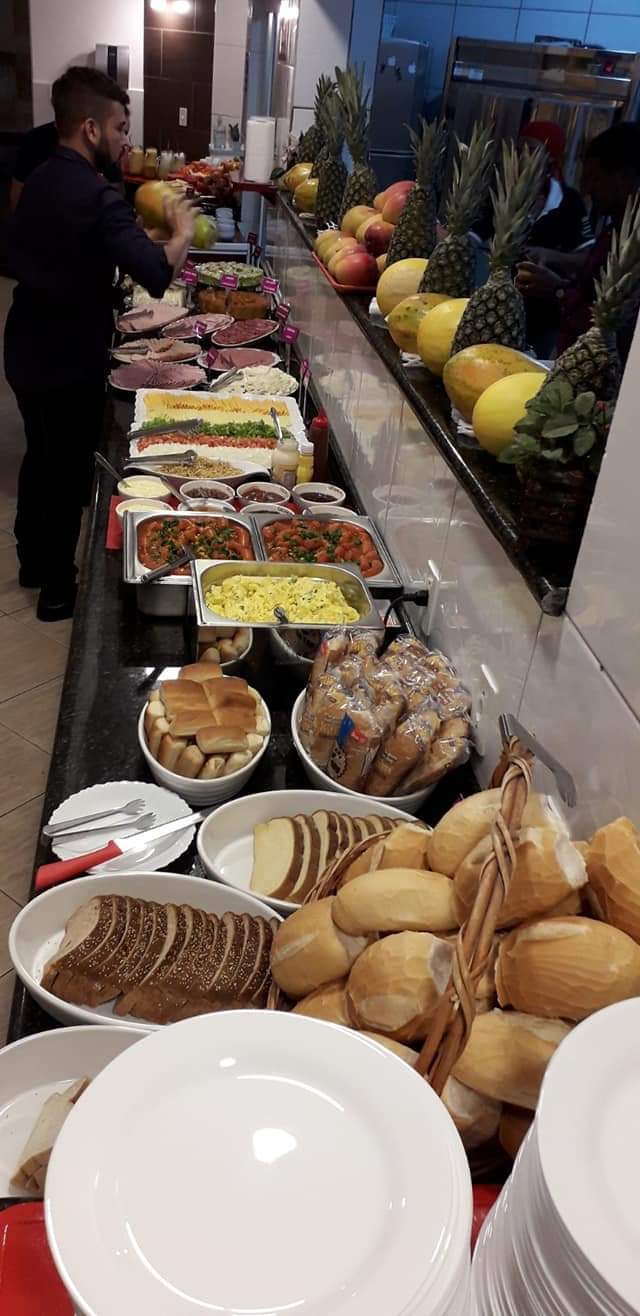 Buffet de café da manhã com pães, frios, ovos mexidos e frutas