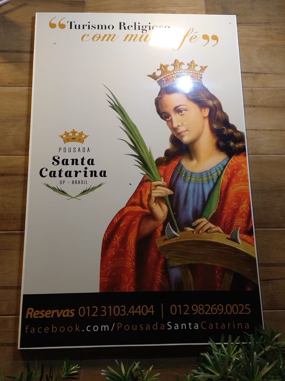 Quadro de Santa Catarina de Alexandria, com coroa, palma e roda, na entrada da pousada