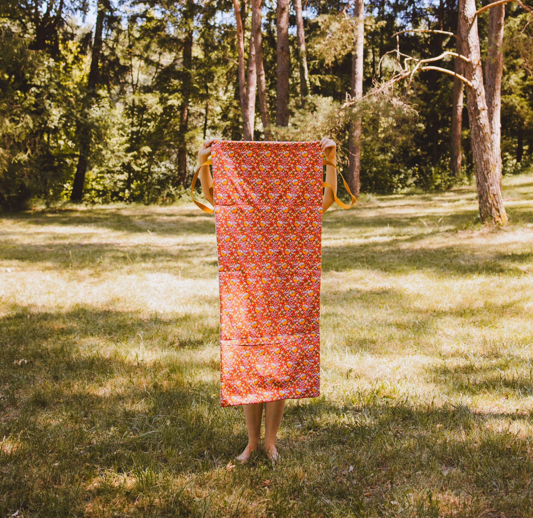 tapis extérieur nap nap solo déplié dans paysage avec jambes qui dépassent coloris bardot imprimé orange