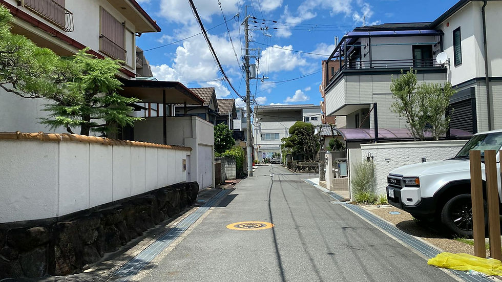 Sunny residential street in Osaka showcasing traditional and modern Japanese architecture.