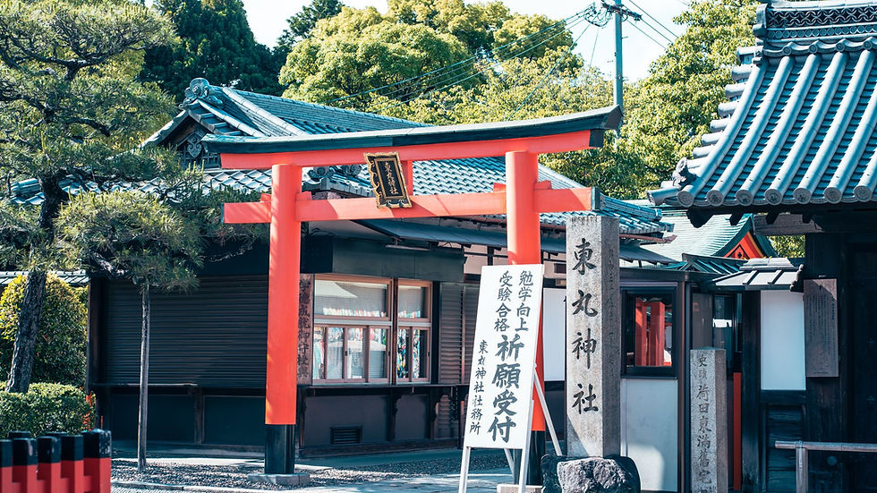 Beautiful torii gate entrance to a shrine in Kyoto, Japan, surrounded by lush greenery.