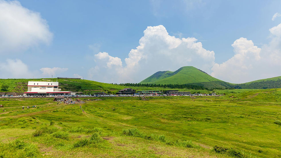 Vibrant green landscape with volcanic hills and blue skies at Aso, Kyushu, Japan.