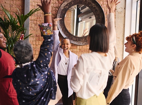 Multi ethnic mixed age range businesswomen cheering in support of International Women's Da