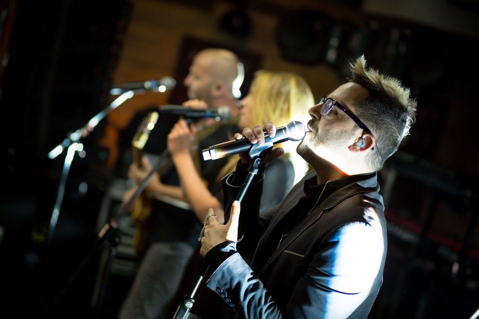 להקה מופיעה עם מיקרופונים. אנשים שרים ומוזיקה, הופעה חיה במועדון.