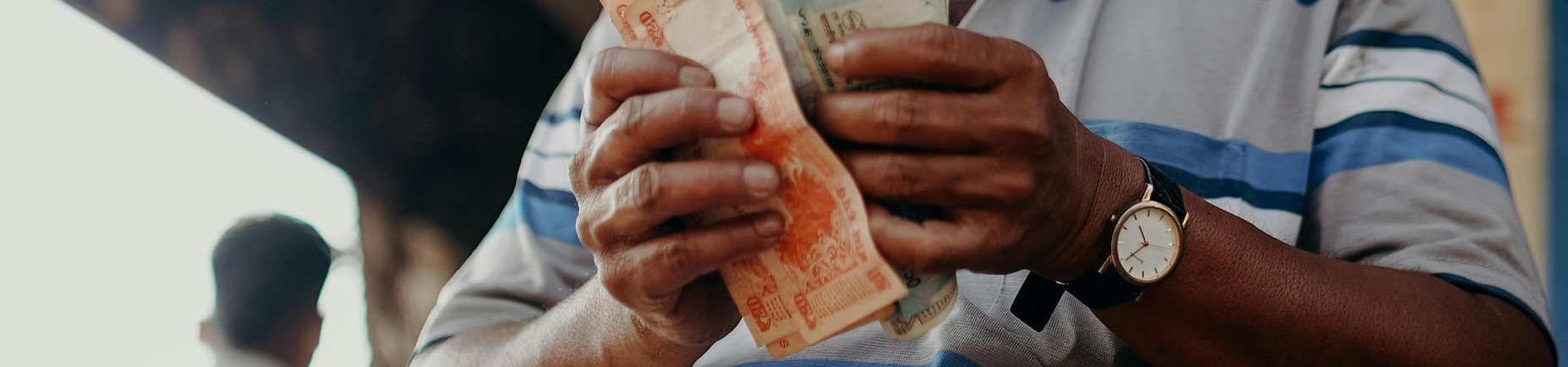 Close up of man counting Indian currency notes